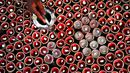 Seorang pembuat tembikar menuangkan lilin ke lampu tanah jelang Festival Diwali di sepanjang pinggir jalan di New Delhi, India, 18 Oktober 2022. Festival Diwali atau dalam agama Hindu berarti Festival Cahaya melambangkan kemenangan baik atas keburukan, dan lampu atau pelita dinyalakan sebagai tanda perayaan serta harapan umat manusia. (Sajjad HUSSAIN/AFP)