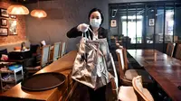 Karyawan dari layanan pengiriman makanan mewah White Glove Delivery mengumpulkan pesanan dari restoran Thailand kelas atas, At-Ta-Rote untuk klien di Bangkok selama pandemi. (LILLIAN SUWANRUMPHA / AFP)