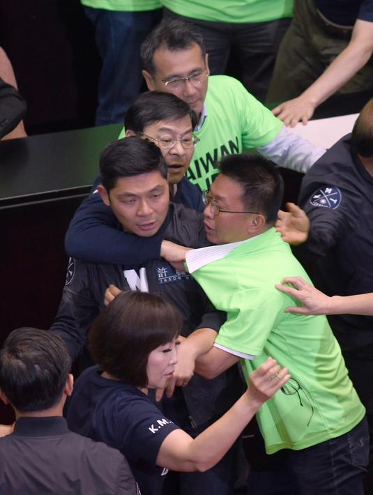 Anggota parlemen dari Partai Progresif Demokratik (DPP) terlibat bentrok dengan Partai Nasionalis Tiongkok atau yang dikenal dengan Kuomintang (KMT) saat melakukan protes di Parlemen di Taipei (20/4). (AFP Photo/Sam Yeh)