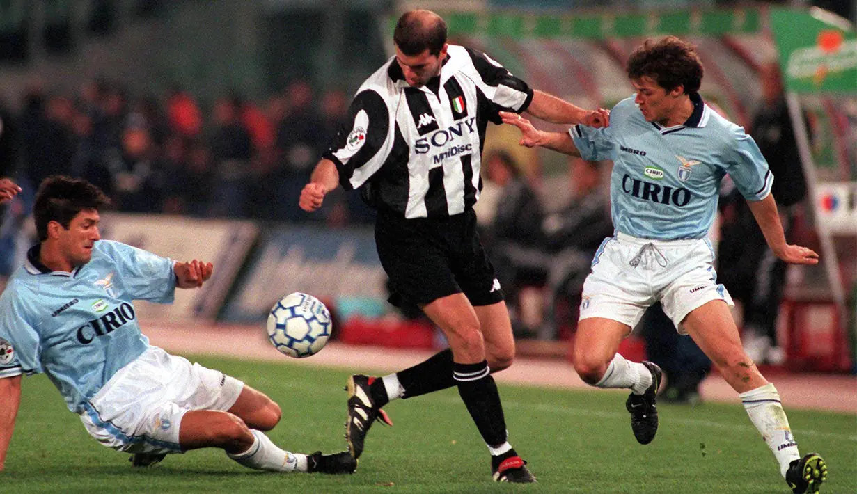 Gelandang Juventus, Zinedine Zidane, berusaha melewati hadangan pemain Lazio pada laga Serie A di Stadion Olimpico, Roma, Minggu (5/4/1998). (EPA/Maurizio Brambatti)