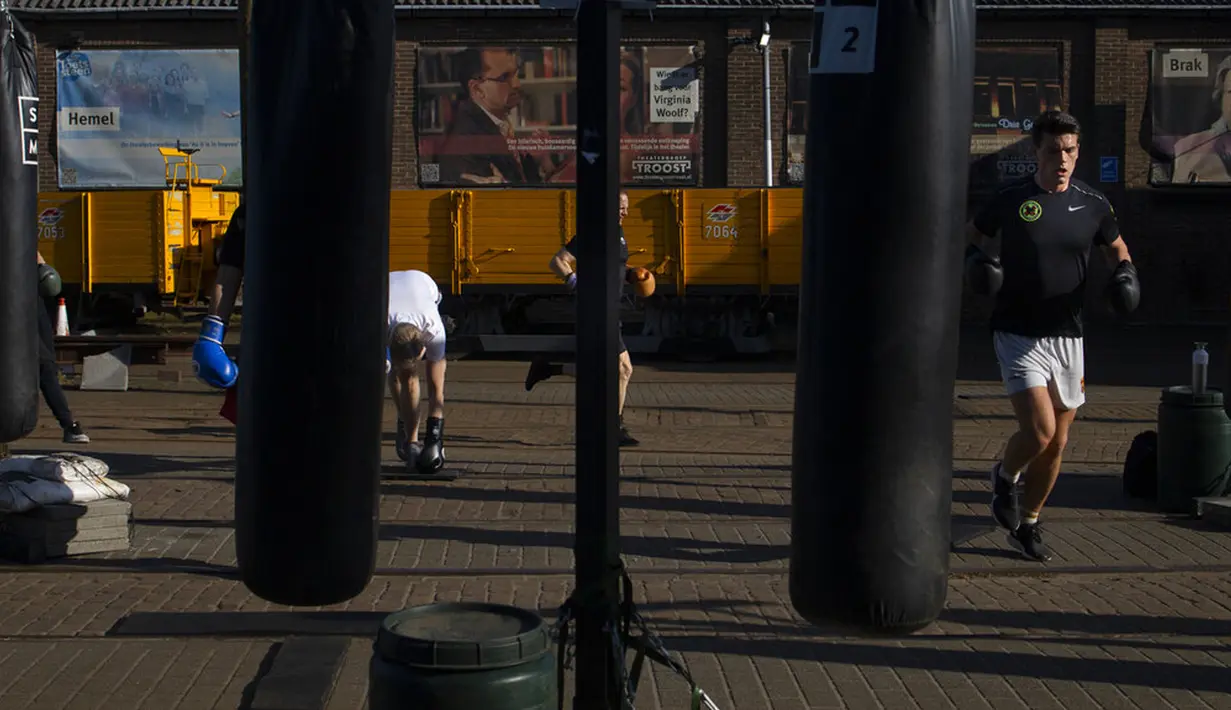 Kickboxer menjaga jarak 1,5 meter mengikuti peraturan protokol kesehatan virus corona COVID-19 pemerintah Belanda saat mereka berlatih di luar ruangan di Amsterdam, Belanda, Selasa (30/3/2021). Kasus COVID-19 di Belanda telah menembus satu juta lebih. (AP Photo/Peter Dejong)