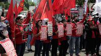 Elemen buruh menggelar aksi unjuk rasa di gedung DPR RI, Jakarta, Selasa (10/1/2023). Massa aksi yang menolak Perppu Cipta Kerja tersebut terlihat membawa bendera berwarna merah memenuhi halaman depan gedung DPR. (Liputan6.com/Faizal Fanani)