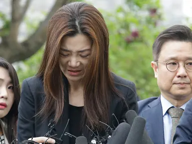 Mantan eksekutif senior Korea Air, Cho Hyun-min dengan kepala tertunduk meminta maaf ketika tiba di kantor polisi Seoul, Selasa (1/5). Cho meminta maaf atas insiden melemparkan minuman di wajah orang pada pertemuan April lalu. (AP/Ahn Young-joon)