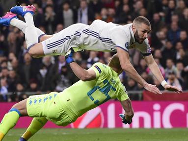Karim Benzema (atas) dihadang kiper Napoli, Pepe Reina pada laga 16 besar Liga Champions di Santiago Bernabeu stadium, Madrid (15/2/2017). Satu gol Benzema mengantarkan Real Madrid menang atas Napoli 3-1.  (AFP/Pierre-Philippe Marcou)