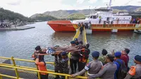 Petugas penyelamat, personel militer, dan polisi membawa penumpang yang telah dievakuasi menggunakan tandu turun dari kapal pencarian dan penyelamatan di Pelabuhan Lembar, Lombok Barat, Rabu, 12 Agustus 2026. (AFP)