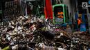 Petugas mengeruk sampah menggunakan alat berat di pintu air Manggarai, Jakarta, Selasa (4/12). Tingginya intensitas hujan di wilayah Jabodetabek membuat sampah yang terbawa arus sungai menumpuk di Pintu Air Manggarai. (Liputan6.com/Faizal Fanani)