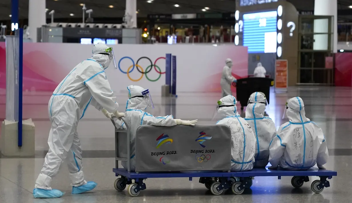 Relawan naik kereta barang di Bandara Internasional Beijing-Capital setelah berakhirnya Olimpiade Musim Dingin 2022, di Beijing, China, Senin (21/2/2022). (APhoto/Frank Augstein)