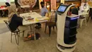 Robot bernama “Bellabot” melintasi pengunjung food court di Tangcity Mal, Kota Tangerang, Rabu (27/10/2021). Robot itu bertugas sebagai pramusaji guna meminimalisir sentuhan langsung antara pegawai dan pengunjung di saat aktivitas mal mulai beroperasi dalam masa pandemi. (Liputan6.com/Angga Yuniar)