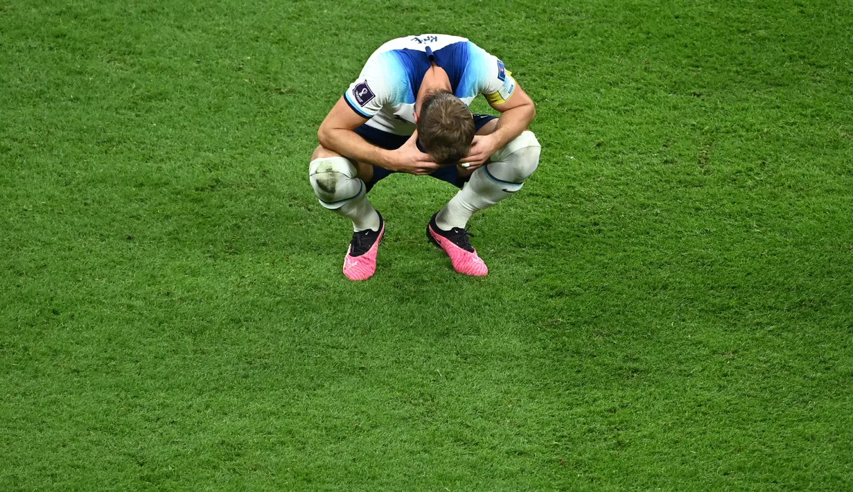Penyerang Inggris #09 Harry Kane bereaksi atas kekalahan timnya dari Prancis pada laga perempat final Piala Dunia 2022, Minggu (11/12/2022) dini hari WIB. Kandasnya The Three Lions di turnamen akbar empat tahunan tersebut juga diwarnai kegagalan penalti Harry Kane. (Jewel SAMAD / AFP)