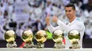 Bintang Real Madrid, Cristiano Ronaldo berpose dengan kelima trofi Ballon d'Or sebelum laga Real Madrid vs Sevilla di Stadion Santiago Bernabeu, Sabtu (9/12). Ronaldo meraih Ballon d'Or 2017 di Paris pada (7/12) lalu. (PIERRE-PHILIPPE MARCOU/AFP)