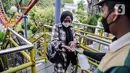 Petugas menyemprotkan cairan disinfektan kepada pengunjung yang akan menaiki wahana bermain di Dunia Fantasi, Ancol, Jakarta, Minggu (10/10/2021). Pelonggaran PPKM level 3 di Jakarta membuat sejumlah tempat wisata kembali ramai didatangi pengunjung. (Liputan6.com/Faizal Fanani)