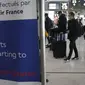 Pelancong untuk Amerika Serikat tiba di meja Air France di bandara Charles de Gaulle, utara Paris, Senin (8/11/2021). Anggota keluarga akan terhubung kembali dengan orang yang dicintai setelah lebih dari satu setengah tahun terpisah karena pandemi. (Foto AP/Christophe Ena)