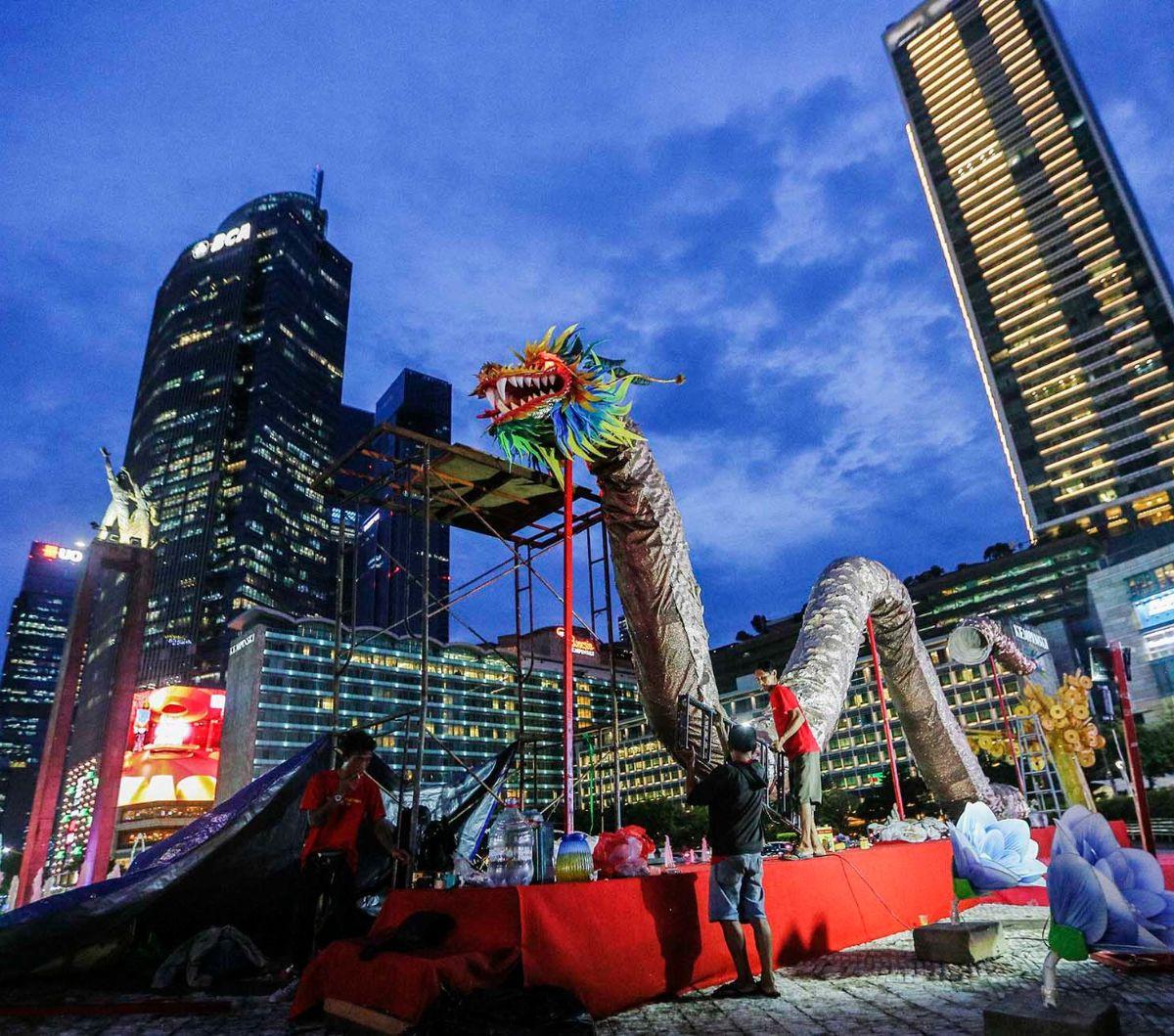 Pekerja memasang dekorasi liong atau naga raksasa di Bundaran HI, Jakarta, Selasa (6/2/2024). Dekorasi yang dipasang&nbsp;Suku Dinas Pertamanan dan Kehutanan DKI ini untuk menyemarakkan Tahun Baru Imlek 2575. Foto: Liputan6.com/Angga Yuniar