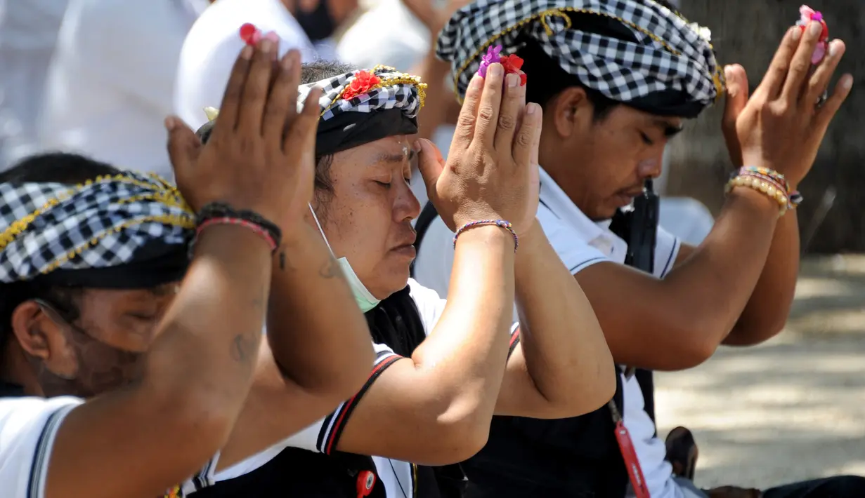 Umat Hindu berdoa saat upacara Melasti menjelang Hari Raya Nyepi Tahun Baru Saka 1943 di Pantai Kuta, Bali (11/3/2021). Ritual Melasti untuk menyucikan alam agar Hari Raya Nyepi dapat berjalan  hening serta damai. (AFP/Sonny Tumbelaka)