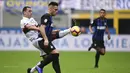Striker Inter Milan, Lautaro Martinez, berebut bola dengan gelandang Genoa, Romulo, pada laga Serie A Italia di Stadion San Siro, Milan, Sabtu (3/11). Inter menang 5-0 atas Cagliari. (AFP/Miguel Medina)