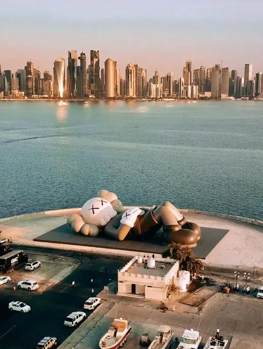 Pada November 2019, KAWS: HOLIDAY kembali  terlihat rebahan. Kali ini, ia berada di Pelabuhan Dhow, Qatar. [Instagram/arr.allrightsreserved]