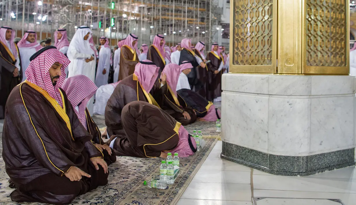 Putra Mahkota Arab Saudi Mohammed bin Salman melaksanakan salat saat meninjau Masjidil Haram di Mekah, Arab Saudi, Selasa (12/2). Pangeran Mohammed datang dengan pengawalan super ketat. (BANDAR AL-JALOUD/SAUDI ROYAL PALACE/AFP)
