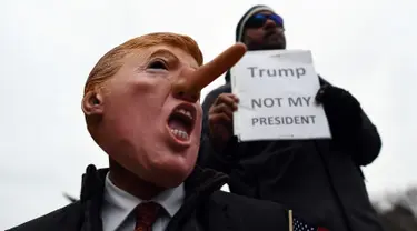 Demonstran menggelar aksi protes jelang pelantikan Donald Trump sebagai Presiden AS di Washington DC, Jumat (20/1). Mereka menolak Trump sebagai Presiden AS. (AFP PHOTO / Jewel SAMAD)