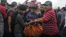Petugas mengevakuasi korban tewas untuk dibawa ke rumah sakit, di sebelah utara Ibu Kota Nepal, Kathmandu, Senin (8/8). Tujuh orang, termasuk bayi dan pilot tewas akibat jatuhnya Helikopter Fishtail Air. (AFP PHOTO/BIKASH Karki)