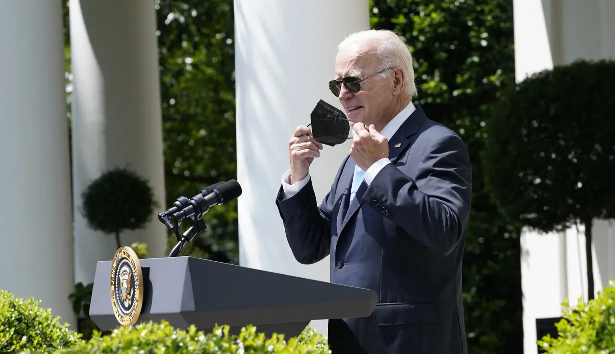 Presiden Amerika Serikat Joe Biden melepas maskernya saat mulai berbicara di Taman Mawar Gedung Putih, Washington, Amerika Serikat, 27 Juli 2022. Biden harus diisolasi di kediamannya di Gedung Putih sejak positif COVID-19 pada Kamis lalu. (AP Photo/Susan Walsh)