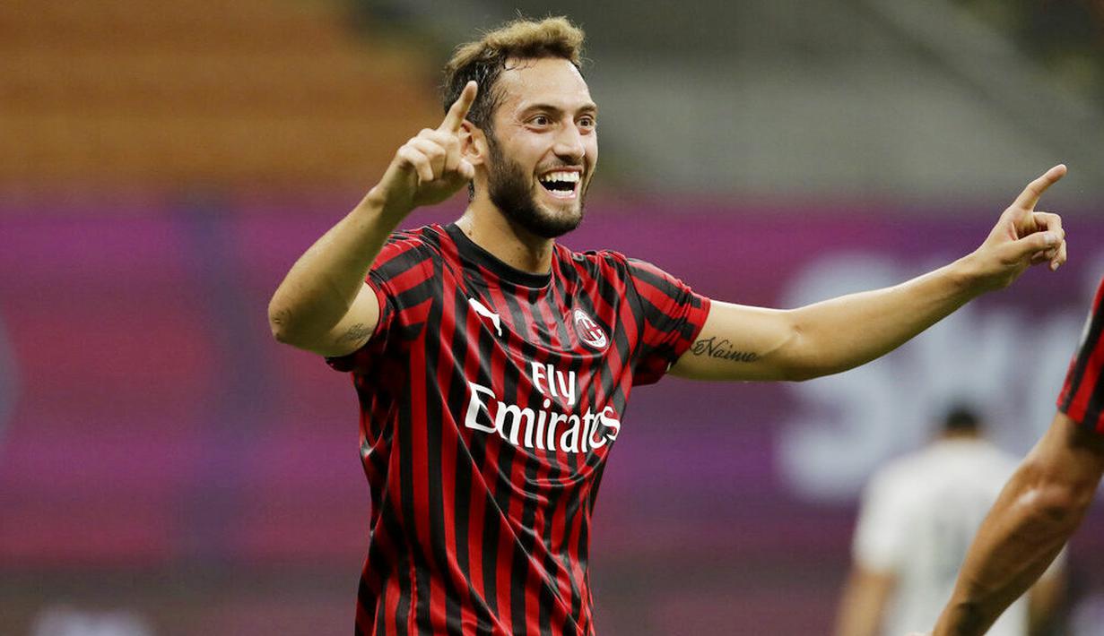 Pemain AC Milan, Hakan Calhanoglu, melakukan selebrasi usai membobol gawang Bologna pada laga Serie A di Stadion San Siro, Sabtu (18/7/2020). AC Milan menang dengan 5-1 atas Bologna. (AP/Luca Bruno)