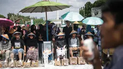 Delapan aktivis dari sejumlah lembaga swadaya masyarakat mengecor kaki mereka di depan Istana Merdeka, Jakarta, Rabu (22/3). Aksi itu merupakan lanjutan dari protes pembangunan pabrik semen di Pegunungan Kendeng, Jawa Tengah. (Liputan6.com/Faizal Fanani)
