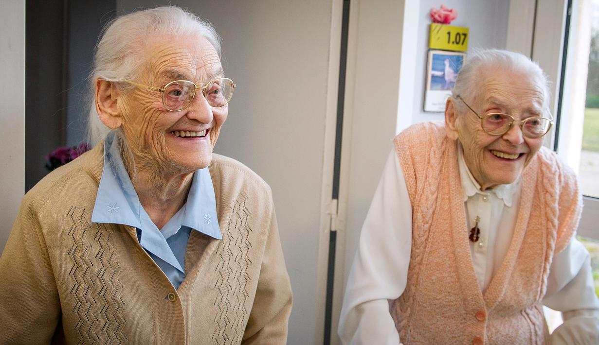 Paulette Olivier (kiri) dan Simone Thiot berbincang saat berada di Ephad "Les Bois Blancs", Prancis (13/2). Paulette dan Simone perempuan berusia 104 tahun ini diyakini sebagai wanita kembar tertua di dunia. (AFP PHOTO/GUILLAUME souvent)