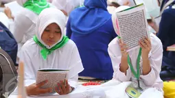 Dua orang santri membaca Al Quran di Gedung Pertamina, Jakarta, Kamis (23/6). Dalam rangka peringatan Nuzulul Quran, Pertamina bersama 27.218 anak yatim se-Jakarta membaca kitab suci Al Quran hingga khatam. (Liputan6.com/Angga Yuniar)