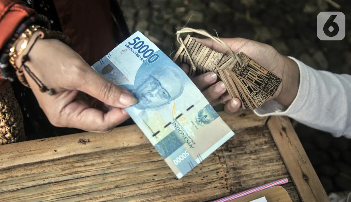 Wisatawan menukarkan uang rupiah dengan uang pring atau bambu di Pasar Papringan, Ngadiprono, Kabupaten Temanggung, Jawa Tengah, Minggu (26/2/2023). Pasar ini mencontoh bagaimana cara hidup nenek moyang di zaman dahulu yang memanfaatkan segala sesuatu dari alam. (merdeka.com/Iqbal S. Nugroho)
