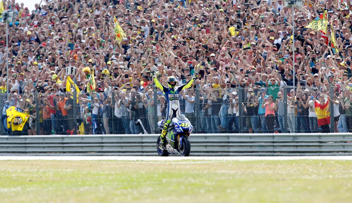 Pembalap tim Movistar Yamaha MotoGP Valentino Rossi merayakan kemenangannya setelah memenangkan Grand Prix di Sirkuit TT di Assen pada 27 Juni 2015. Rossi akan menyelesaikan musim 2021 dan kemudian mundur dari balapan yang membesarkan namanya. (AFP/Bas Czerwinski/ANP)