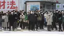 Orang-orang memakai masker untuk melindungi dari penyebaran virus corona menunggu di persimpangan di Tokyo (8/2/2021).  Jumlah infeksi virus corona di Ibu Kota Tokyo, Jepang, meningkat sampai sembilan kali lipat sejak akhir musim panas lalu. (AP Photo/Eugene Hoshiko)