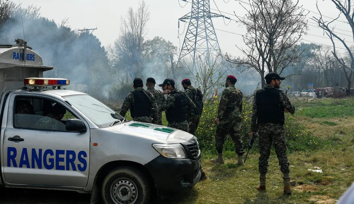 Tentara mengamankan lokasi jatuhnya jet tempur F-16 Pakistan saat latihan jelang parade militer Hari Pakistan di Islamabad, Rabu (11/3/2020). Belum ada konfirmasi lebih lanjut bagaimana nasib pilot dan co-pilot pesawat nahas tersebut. (Aamir QURESHI/AFP)