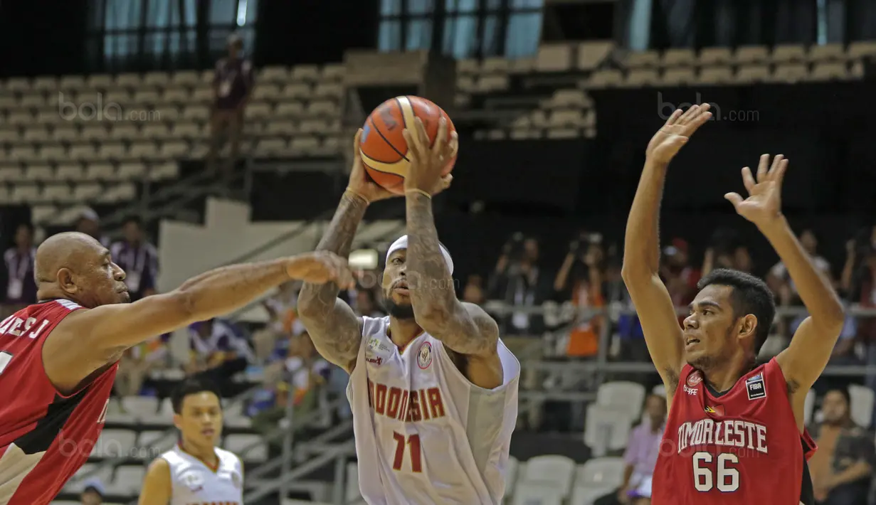 Pemain Timnas Basket Indonesia, Jamarr Johnson (tengah) melewati adangan dua pemain Timor Leste pada laga perdana test event Basketball Asian Games 2018 di Hall A Senayan, Jakarta, Rabu (7/2/2018).  Indonesia menang 135-30. (Bola.com/Nicklas Hanoatubun)