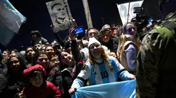 Ratusan orang berdiri di pinggir jalan menyambut kepulangan Lionel Messi dkk. (Luis ROBAYO/AFP)