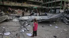 Seorang anak perempuan Palestina melihat reruntuhan sekolah Fatima Bint Asad yang dihantam serangan semalam oleh Israel di Jabalia, Jalur Gaza utara, Senin 12 Mei 2025. (Bashar TALEB/AFP)
