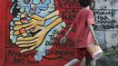 Anak anak melintasi mural ajakan melawan COVID-19 di Depok, Jawa Barat, Selasa (14/4/2020). Pemprov Jawa Barat akan memulai pembatasan sosial skala besar di Bogor, Depok, Bekasi pada Rabu (15/4) dengan menyiapkan anggaran Rp4 triliun sebagai jaring pengaman sosial. (Liputan6.com/Helmi Fithriansyah)