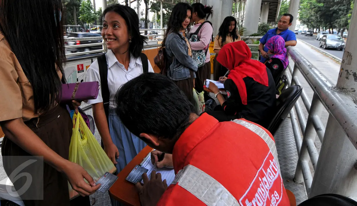 Petugas Transjakarta mendata para pelajar sebelum menaiki bus di halte Gelora Bung Karno, Jakarta, Rabu (29/7/2015). Transjakarta mengratiskan pelajar pemilik KJP selama periode 27 Juli-3 Agustus dalam rangka Jakarta Book Fair. (Liputan6.com/Yoppy Renato)