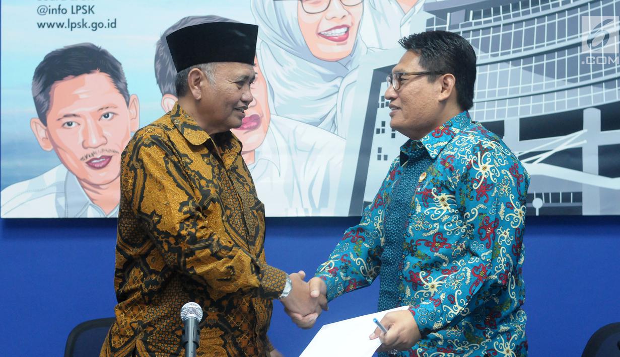 Ketua KPK Agus Rahardjo (kiri) bersalaman dengan Ketua LPSK Abdul Haris Semendawai usai memberi keterangan terkait nota kesepahaman, Jakarta, Selasa (17/4). LPSK dan KPK memperbarui kerja sama perlindungan saksi Tipikor. (Liputan6.com/Helmi Fithriansyah)