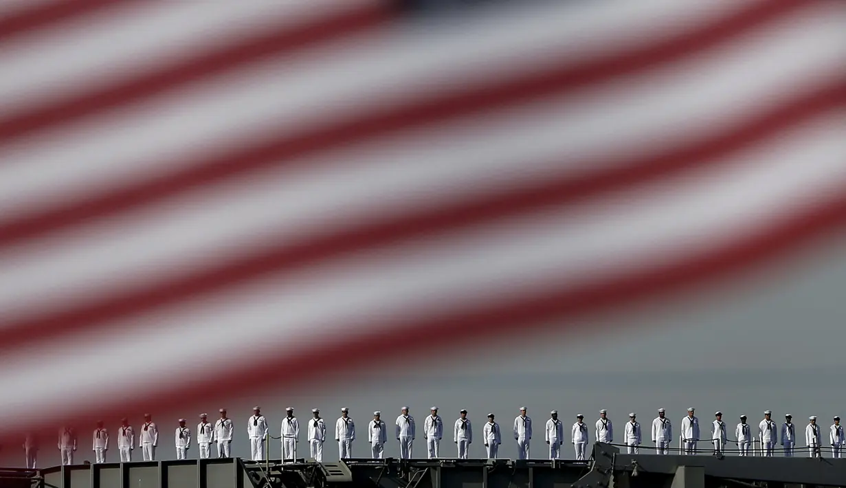 Prajurit Angkatan Laut AS berdiri di atas dek kapal induk USS Ronald Reagan saat tiba di pangkalan angkatan laut Yokosuka, Tokyo, Jepang, Kamis (1/10/2015). USS Ronald Reagan tiba di Jepang sehari lebih awal dari yang dijadwalkan. (REUTERS/Yuya Shino)