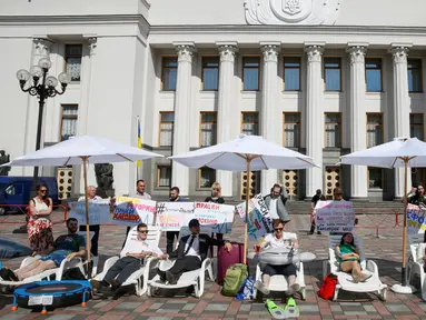 Sejumlah aktivis melakukan aksi di depan gedung parlemen Kiev, Ukraina, (12/7). Mereka menuntut para anggota parlemen untuk bekerja dan menyelesaikan tugas mereka dengan cepat bukannya mengundur waktu. (REUTERS / Valentyn Ogirenko)