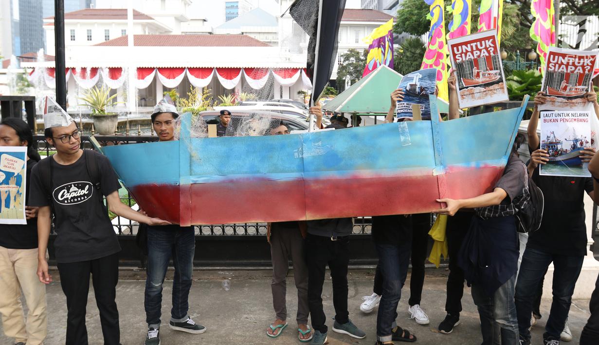Massa yang tergabung dalam Koalisi Selamatkan Teluk Jakarta menggelar aksi jalan mundur menuju Balai Kota di Jakarta, Senin (24/6). Dalam aksinya mereka meminta kepada Gubernur DKI Jakarta untuk mencabut kembali keputusan penerbitan IMB di Pulau C dan D reklamasi Teluk Jakarta. (Liputan6.com/Angga Y