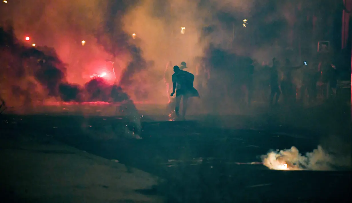 Suasana bentrokan antara suporter PSG dengan polisi anti huru-hara Prancis di sekitar stadion Parc des Princes pada 23 Agustus 2020, setelah pertandingan final Liga Champions antara PSG dan Bayern Munich dimainkan di stadion Luz di Lisbon. (Alain JOCARD / AFP)