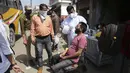 Seorang petugas kesehatan mengumpulkan sampel seorang penumpang untuk diuji COVID-19 di sebuah terminal bus di Jammu, India (26/3/2021). Pemerintah India telah mengumumkan rencana untuk menyuntik 300 juta orang pada Agustus. (AP Photo/Channi Anand)