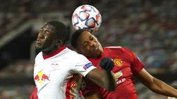 Penyerang Manchester United, Anthony Martial, duel udara dengan pemain RB Leipzig, Ibrahima Konate, pada laga Liga Champions di Stadion Old Trafford, Kamis (29/10/2020). MU menang dengan skor 5-0. (AP/Dave Thompson)