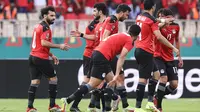 Penyerang Mesir Mohamed Salah (kiri) berselebrasi setelah mencetak gol ke gawang Maroko pada pertandingan perempat final Piala Afrika (CAN) 2021 di Stade Ahmadou Ahidjo di Yaounde (30/1/2022). Mesir menang atas Maroko 2-1. (AFP/Kenzo Tribouillard)