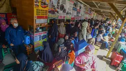 Para calon penumpang memilih berangkat lebih awal untuk menghindari kepadatan dan memanfaatkan penawaran tarif terjangkau. Tampak dalam foto, para calon penumpang menunggu waktu keberangkatan di Agen Bus Pondok Pinang, Jakarta Selatan, Sabtu (14/3/2026). (merdeka.com/Arie Basuki)