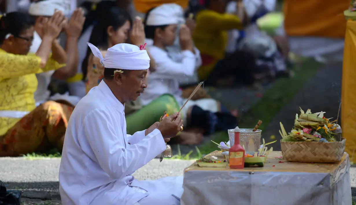 Seorang pria Hindu melakukan persembahyangan Hari Raya Galungan di Pura Jagat Natha di Denpasar, Bali (1/11). Galungan dimaknai sebagai hari kemenangan Dharma (Kebaikan) melawan Adharma (Keburukan). (AFP Photo/Sonny Tumbelaka)