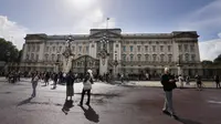 Turis berdiri di depan Istana Buckingham di London, Kamis (8/9/2022).  Istana Buckingham mengatakan Ratu Elizabeth II telah ditempatkan di bawah pengawasan medis karena dokter "memperhatikan kesehatan Yang Mulia." Anggota keluarga kerajaan pergi ke Skotlandia untuk bersama raja berusia 96 tahun itu. (AP Photo/Frank Augstein)