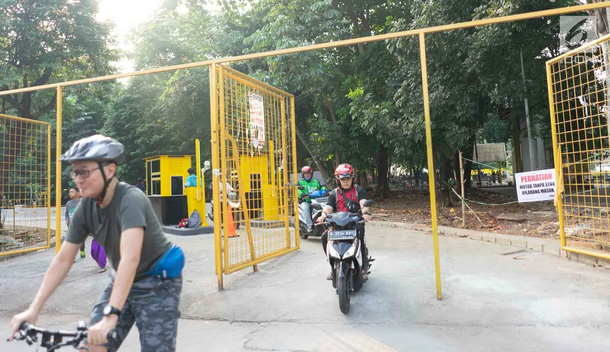 Pengendara motor melintasi akses pintu masuk dan keluar Universitas Indonesia di Depok, Jawa Barat, Selasa (16/7/2019). Penerapan uji coba sistem masuk parkir UI berbayar yang menyebabkan kemacetan panjang membuat gerbang tiket pembayaran kembali dinonaktifkan. (Liputan6.com/Immanuel Antonius)