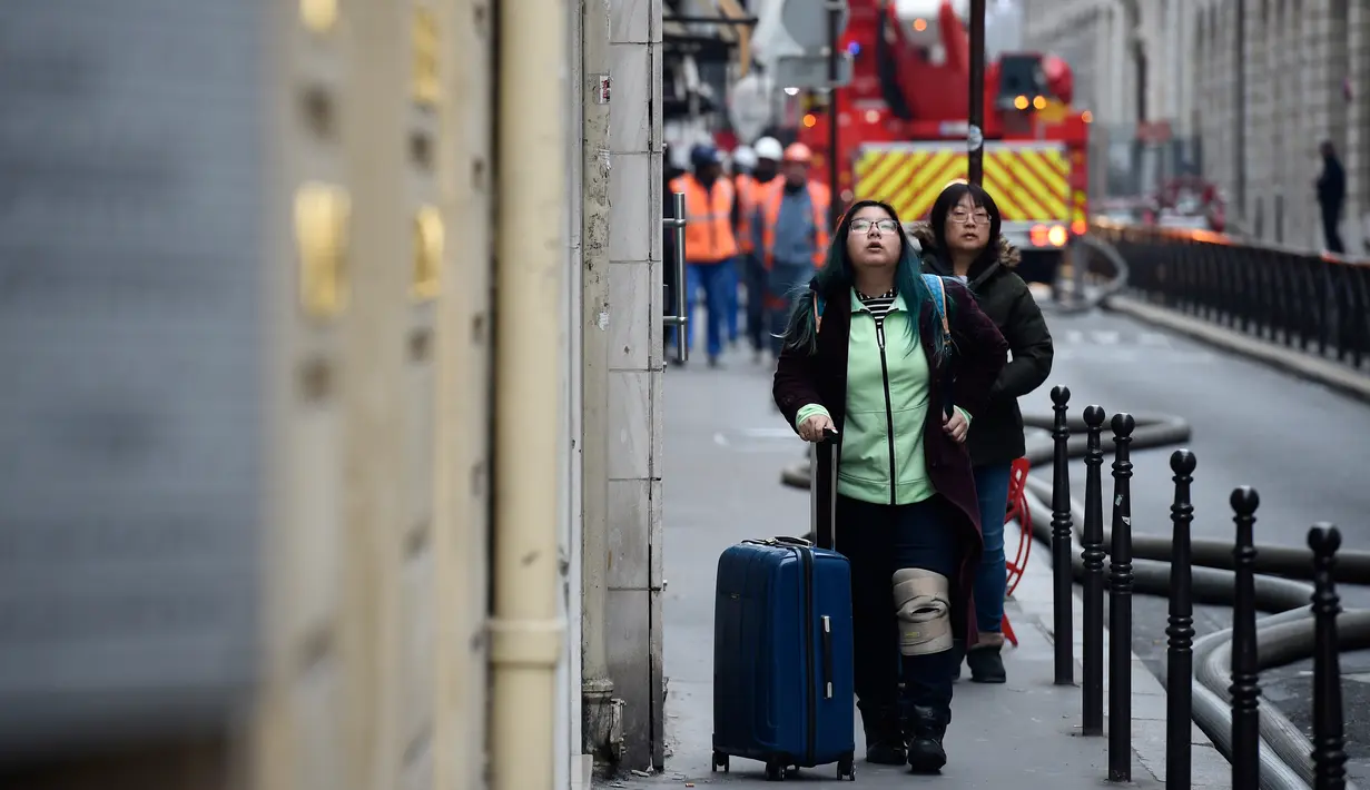 Dua wanita menyaksikan kebakaran di Hotel Ritz, Paris, Selasa (19/1). Hotel ini pernah menjadi tempat Putri Diana dan Dodi Fayed menghabiskan malam terakhir sebelum tewas dalam kecelakaan mobil pada 1997. (AFP PHOTO/Lionel Bonaventure)